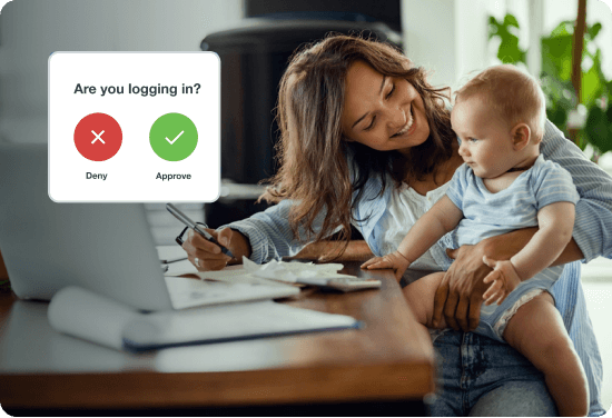 Safest access management - woman sitting at desk working holding baby smiling, with log in icon 